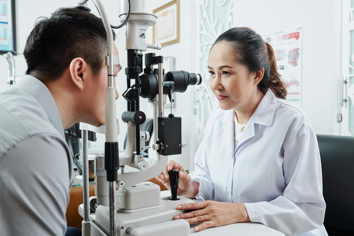 A-female-optometrist-examining-a-patients-eyesight-using-specialist-medical-equipment
