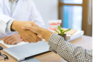 Dentist Shaking Hands With New Associate